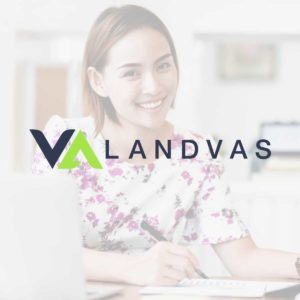 Smiling VA working on a computer with the LandVAs logo over it
